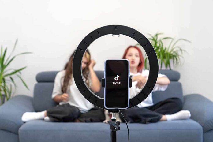 shutterstock_2170134629 smartphone on ring light filming two people on a couch