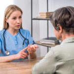 Healthcare professional consulting with an older woman at a desk