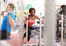 How Strength Training Affects Mood & Mental Health Woman lunging on sled in gym next to man using cable machine