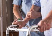 Elderly person using a walker with caregiver support