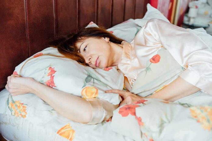 woman lying in bed looking pensive