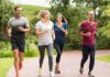 Group of four adults jogging on a park path