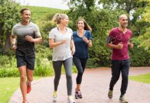 Group of four adults jogging on a park path
